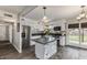 Bright kitchen features stainless appliances, modern finishes, an island with bar seating, and backyard access at 5801 W Cortez St, Glendale, AZ 85304