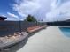 An in-ground pool area enclosed by a stone-lined flower bed, perimeter seating, and tall fence for privacy and comfort at 5801 W Cortez St, Glendale, AZ 85304