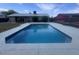 Backyard with large in-ground pool surrounded by a concrete deck, benches, and grass for recreation and relaxation at 5801 W Cortez St, Glendale, AZ 85304
