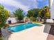 The backyard features a pool, decorative wall art, covered patio, and mature trees at 6154 E Karen Dr, Scottsdale, AZ 85254
