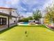 A backyard featuring a covered patio, pool, putting green, and a mural is perfect for entertaining at 6154 E Karen Dr, Scottsdale, AZ 85254