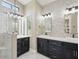 Modern bathroom featuring a walk-in shower and a dual sink vanity with black cabinets at 6154 E Karen Dr, Scottsdale, AZ 85254