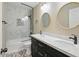 Modern bathroom featuring a tub-shower combination with marble-look tile and a dual sink vanity with black cabinets at 6154 E Karen Dr, Scottsdale, AZ 85254