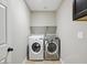 The laundry room showcases a front load washer and dryer, storage shelf, and convenient electrical outlets at 6154 E Karen Dr, Scottsdale, AZ 85254