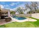 Backyard pool featuring a putting green, waterfall, and deck with built in grill at 6204 W Hedgehog Pl, Phoenix, AZ 85083