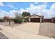 Inviting home exterior featuring a well-maintained driveway and desert landscaping at 6313 W Paradise Ln, Glendale, AZ 85306