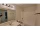 Clean bathroom with white fixtures, including a vanity, toilet, and shower-tub combo, featuring a large mirror at 6784 W Gardenia Ave, Glendale, AZ 85303