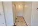 Inviting hallway with neutral colored walls and stone tile floors, leading to the front door at 6784 W Gardenia Ave, Glendale, AZ 85303