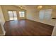Bright and spacious living room featuring wood floors, a ceiling fan, large windows, and sliding glass doors to the backyard at 6784 W Gardenia Ave, Glendale, AZ 85303