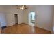Inviting bedroom with hardwood floors, a ceiling fan, closet, and arched entry to an en-suite bathroom at 6784 W Gardenia Ave, Glendale, AZ 85303