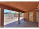 Covered back patio with brick flooring, outdoor lighting, and backyard access at 7038 W Fillmore St, Phoenix, AZ 85043