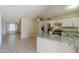 Open kitchen with white cabinets, granite countertops, and stainless steel appliances at 7038 W Fillmore St, Phoenix, AZ 85043