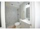 Updated bathroom with a gray vanity, white toilet, and a walk-in shower with marble-look tile at 7136 W Cheryl Dr, Peoria, AZ 85345
