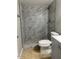 Elegant walk-in shower adorned with modern marble-look tile and pebble floor at 7136 W Cheryl Dr, Peoria, AZ 85345