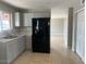 Well-lit kitchen featuring modern cabinets, a sleek black refrigerator, and tile flooring at 7136 W Cheryl Dr, Peoria, AZ 85345