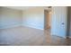 Spacious living room featuring ceramic tile flooring, neutral walls, and a white door on the right at 7136 W Cheryl Dr, Peoria, AZ 85345