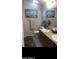 Cozy bathroom with double sinks, decorated with beach-themed artwork and towel at 8700 E University Dr # 124, Mesa, AZ 85207