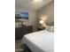 Bedroom featuring a cozy bed with decorative pillows and a dresser with beach-themed artwork at 8700 E University Dr # 124, Mesa, AZ 85207