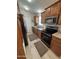 Functional kitchen with wooden cabinetry, modern appliances, and light wood flooring at 8700 E University Dr # 124, Mesa, AZ 85207