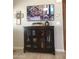 Living room display with wood cabinet and glass doors, wall art, and decorative items at 8700 E University Dr # 124, Mesa, AZ 85207