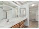 Bathroom featuring a vanity, large mirror, and an adjacent walk-in closet at 11529 E Lindner Ave, Mesa, AZ 85209