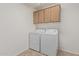 Practical laundry room with washer and dryer, plus overhead cabinets for storage solutions at 11529 E Lindner Ave, Mesa, AZ 85209