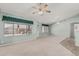Large living room with ceiling fans, neutral carpet, and natural light from windows, creating a serene retreat at 11529 E Lindner Ave, Mesa, AZ 85209