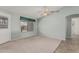 Open living room featuring neutral carpet, a ceiling fan, and a door leading to the exterior, great for entertaining at 11529 E Lindner Ave, Mesa, AZ 85209
