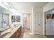 Bathroom featuring double sinks, tile floors, and three doors leading to other rooms at 14575 W Mountain View Blvd # 11212, Surprise, AZ 85374