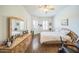 Bright main bedroom with a ceiling fan, dresser and a large bed with soft white bedding at 14575 W Mountain View Blvd # 11212, Surprise, AZ 85374
