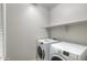 Convenient laundry room with a full-size washer and dryer and built in shelving at 14870 W Encanto Blvd # 1106, Goodyear, AZ 85395