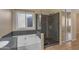 Elegant bathroom with a glass-enclosed shower, a soaking tub, and modern fixtures for a relaxing retreat at 16040 W Grant St, Goodyear, AZ 85338