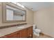 Bathroom showcasing a vanity with granite counters, a tile backsplash, and a stylish mirror and lighting at 16040 W Grant St, Goodyear, AZ 85338