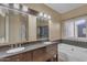 Beautiful bathroom featuring dual sinks, a soaking tub, and stylish fixtures for a spa-like experience at 16040 W Grant St, Goodyear, AZ 85338