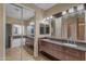Luxurious bathroom with dual vanities, decorative mirrors, and a separate tub and shower area at 16040 W Grant St, Goodyear, AZ 85338