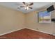 A simple bedroom features wood-look flooring, a window, and mounted TV for a relaxing retreat at 16040 W Grant St, Goodyear, AZ 85338