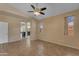 Bright bedroom features wood-look flooring, a ceiling fan, and ample natural light from multiple windows at 16040 W Grant St, Goodyear, AZ 85338