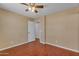 Bright bedroom featuring a ceiling fan, wood-look floors, and an open door to add depth at 16040 W Grant St, Goodyear, AZ 85338