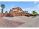 Three-car garage with an extended driveway and desert landscaping provides plenty of parking at 16040 W Grant St, Goodyear, AZ 85338