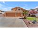 Lovely home with a three-car garage, well-maintained lawn, mature desert landscaping, and tiled roof at 16040 W Grant St, Goodyear, AZ 85338