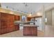 Open kitchen with an island, wooden cabinets, and modern appliances, offering plenty of space for cooking and entertaining at 16040 W Grant St, Goodyear, AZ 85338