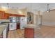 Stylish kitchen featuring an island, wooden cabinets, and updated appliances, seamlessly connecting to the adjacent living areas at 16040 W Grant St, Goodyear, AZ 85338