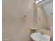 Compact powder room featuring a pedestal sink, modern fixtures, and neutral wall color at 16040 W Grant St, Goodyear, AZ 85338