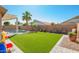 Lush backyard with artificial turf, a fenced pool area, and ample seating, creating a private outdoor oasis at 16817 W Bradford Way, Surprise, AZ 85374