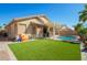 Beautiful backyard showcasing artificial turf, a pool, covered patio and playful area at 16817 W Bradford Way, Surprise, AZ 85374