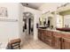 Bathroom featuring double sinks with wood countertops, an open design, and access to the walk-in closet at 16817 W Bradford Way, Surprise, AZ 85374