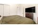 Bedroom with a queen bed, closet with white doors, television, and side table at 16817 W Bradford Way, Surprise, AZ 85374