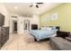 Spacious bedroom features neutral green walls, tile flooring, blue bed, and a sitting area at 16817 W Bradford Way, Surprise, AZ 85374