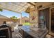 Inviting covered patio with a stylish outdoor dining set and grill, perfect for entertaining or relaxing outdoors at 16817 W Bradford Way, Surprise, AZ 85374