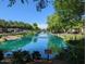 Scenic view of the community pond with a fountain, surrounded by mature trees and well-manicured landscaping at 1814 E Bridgeport Pkwy # 103, Gilbert, AZ 85295